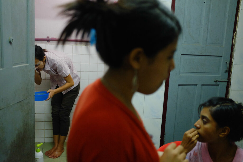 Phway Phway (L, Christian) washes her face as Khin Zar Mon (C, Muslim) and Thwe Thwe Oo (R, Christian) chatting in the kitchen.