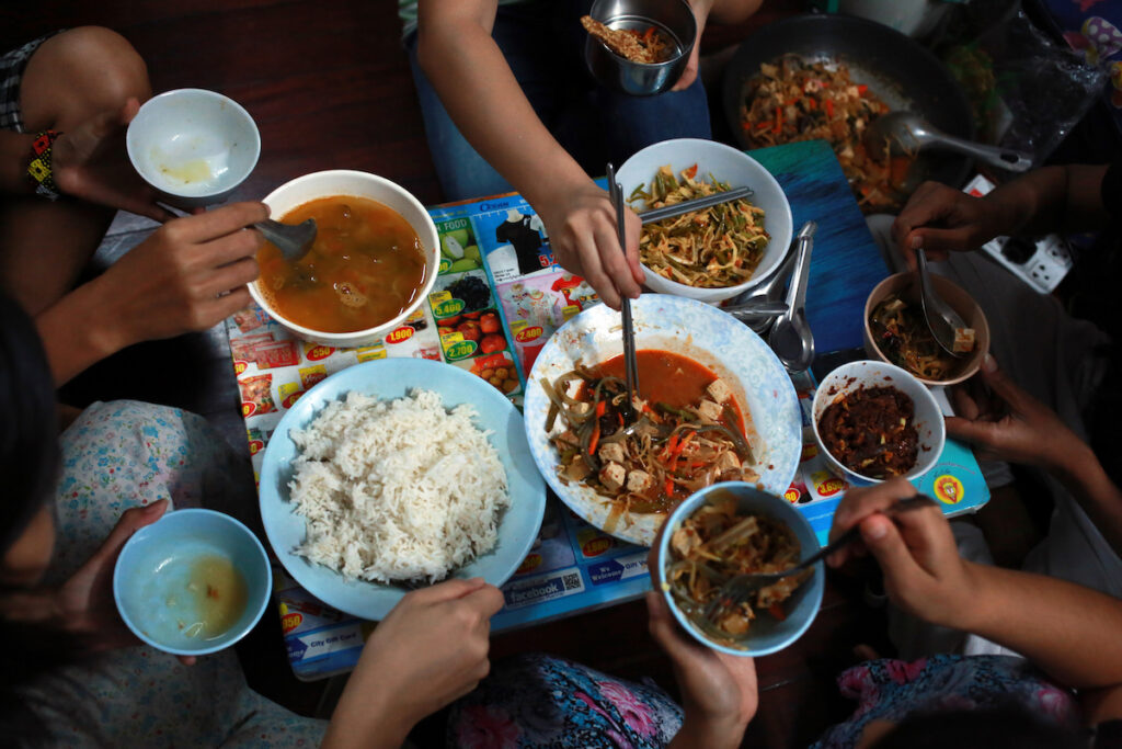 6 girls all together sit for dinner in living room.