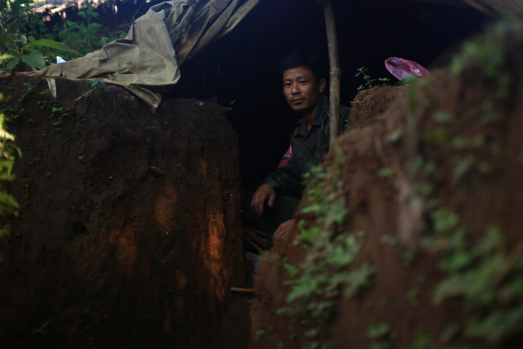 A KIA soldier rests in a foxhole near the frontline at Lawa Yang, Kachin State.